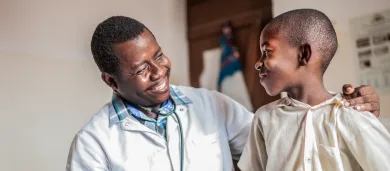 Male doctor smiling at male child patient